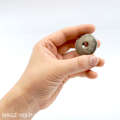 Foto av en hånd med magneten i for enklere illustrasjon av størrelsen